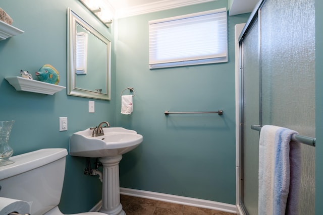 bathroom featuring toilet, a shower with door, and crown molding