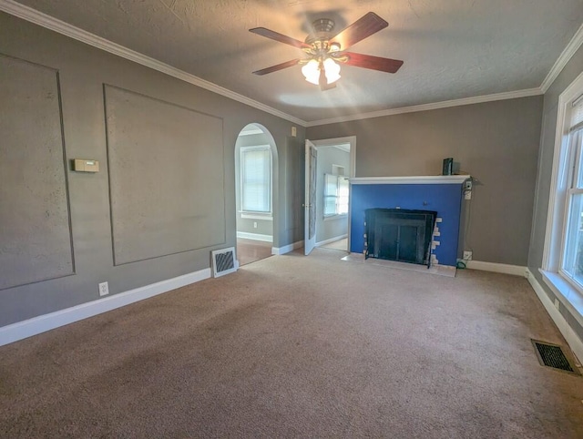 unfurnished living room featuring light carpet, ceiling fan, a textured ceiling, and ornamental molding