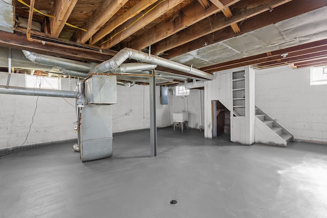 basement with sink, electric panel, and heating unit