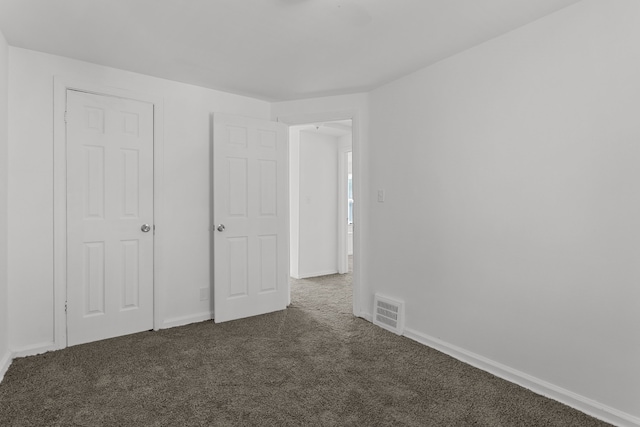 unfurnished bedroom with dark carpet