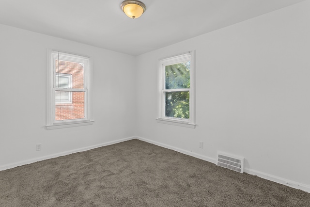 spare room featuring dark carpet