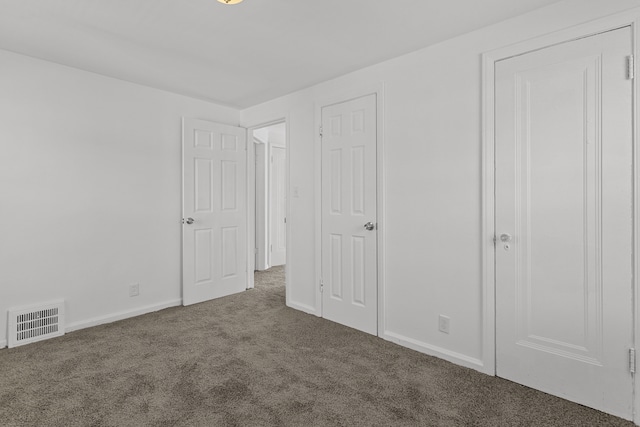 unfurnished bedroom with dark carpet