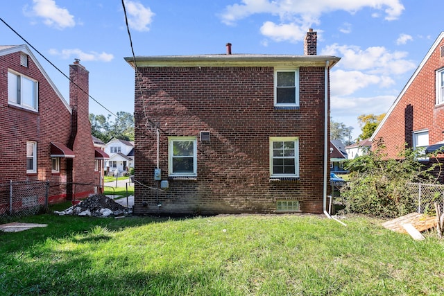 back of property featuring a lawn