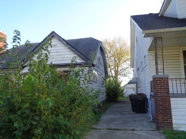 view of side of property with a porch and a garage