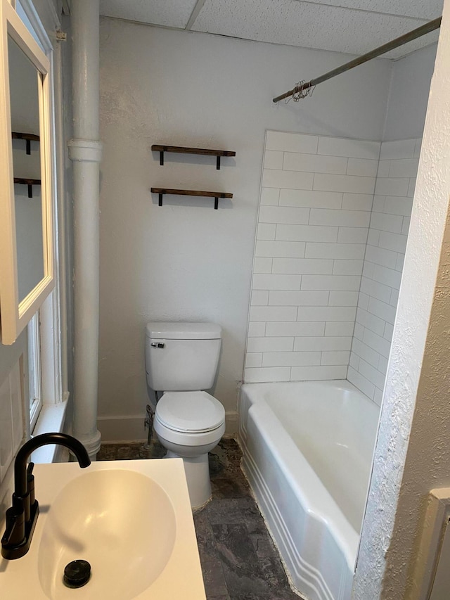 full bathroom with sink, tiled shower / bath combo, and toilet