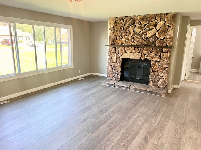 unfurnished living room with wood-type flooring and a fireplace