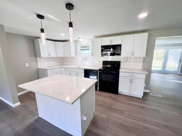 kitchen with black appliances, dark hardwood / wood-style floors, white cabinets, and decorative light fixtures