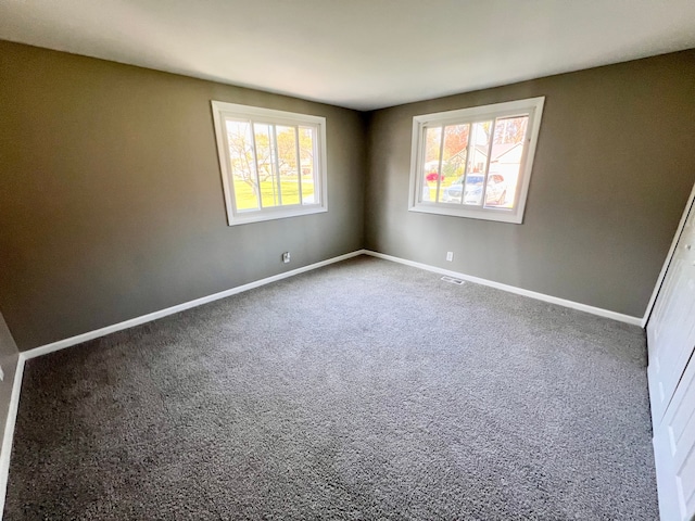 carpeted empty room featuring plenty of natural light