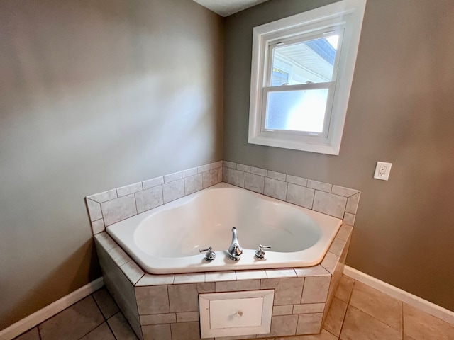 bathroom with tiled tub and tile patterned flooring