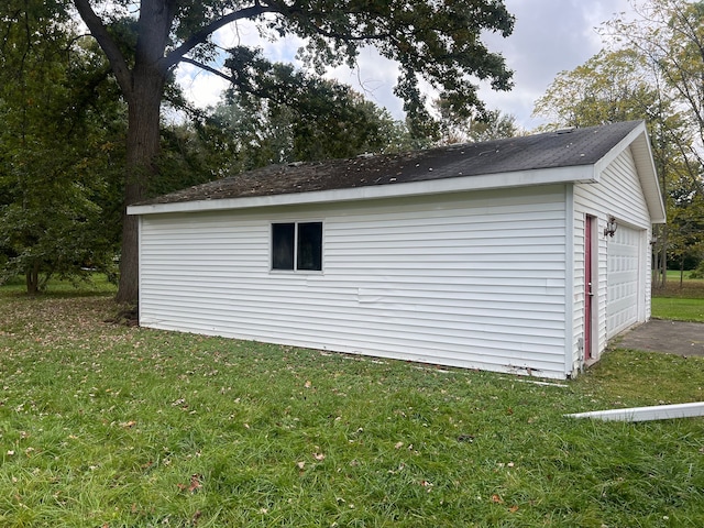 view of outdoor structure featuring a lawn and a garage