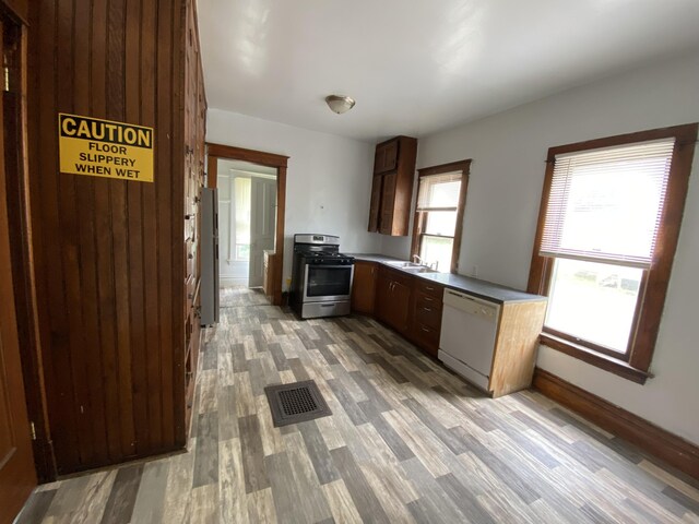 925 W Lovell St, Kalamazoo, MI 49007 - kitchen with stainless steel appliances, light wood finished floors, a sink, baseboards, and light countertops