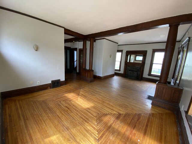 925 W Lovell St, Kalamazoo, MI 49007 - unfurnished living room featuring decorative columns, baseboards, and a fireplace