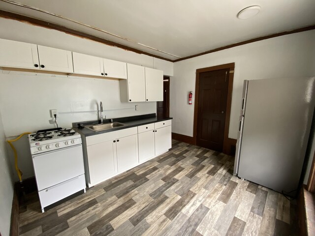 925 W Lovell St, Kalamazoo, MI 49007 - kitchen featuring white range with gas cooktop, a sink, freestanding refrigerator, dark countertops, and white cabinets