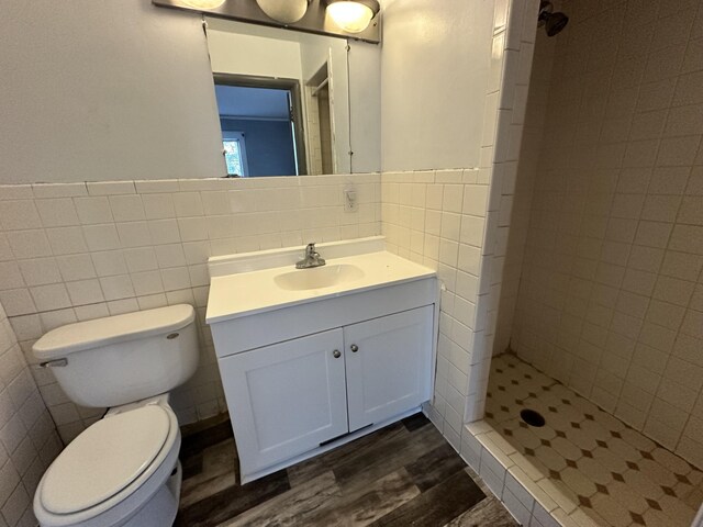925 W Lovell St, Kalamazoo, MI 49007 - bathroom with tile walls, wood finished floors, vanity, a tile shower, and toilet