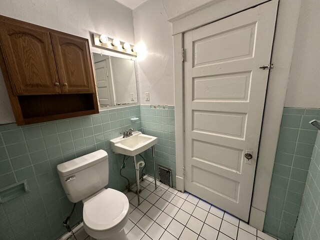 925 W Lovell St, Kalamazoo, MI 49007 - half bath featuring tile walls, tile patterned floors, wainscoting, and toilet