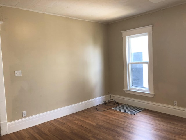 spare room with hardwood / wood-style floors and crown molding