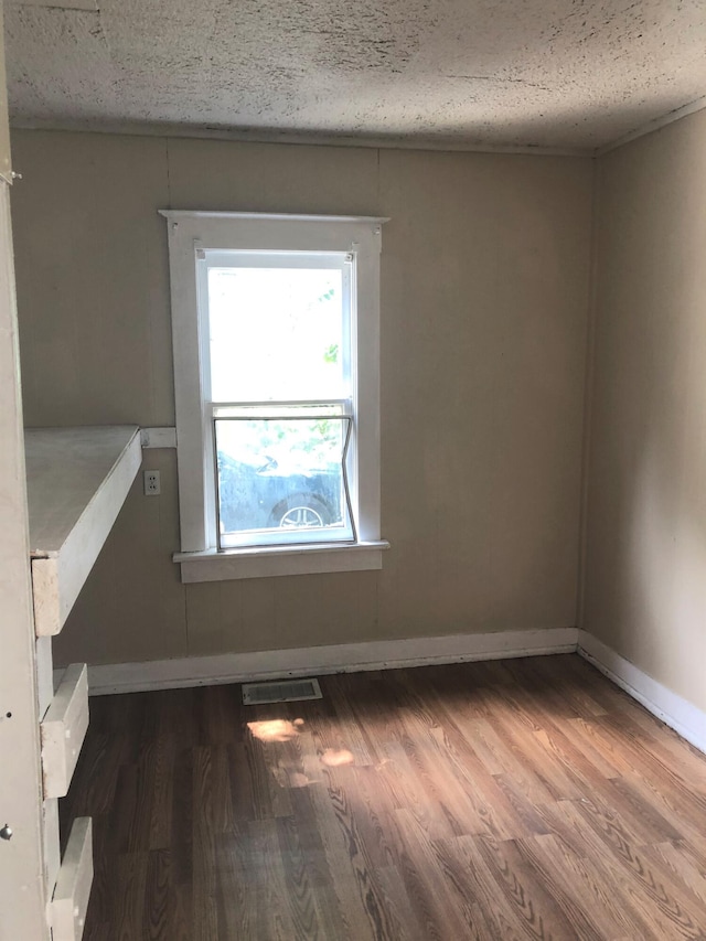 unfurnished room featuring hardwood / wood-style floors and a textured ceiling