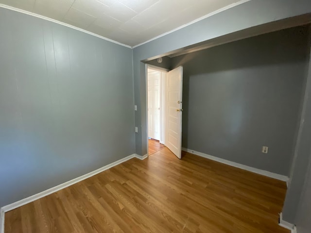 spare room featuring hardwood / wood-style floors and ornamental molding