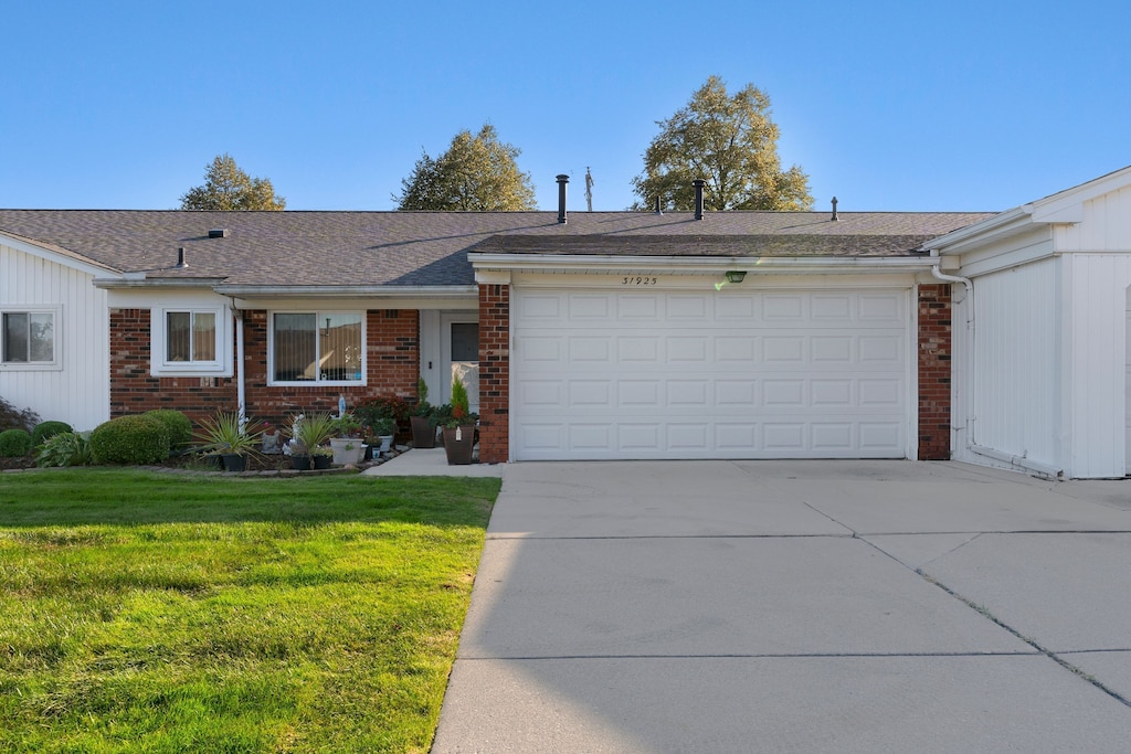 ranch-style house with a garage and a front lawn