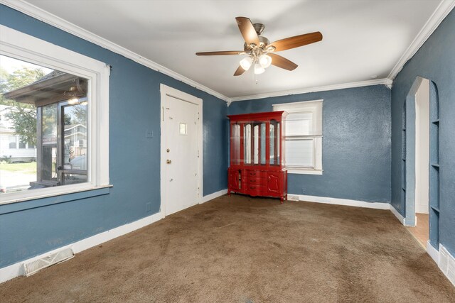 carpeted spare room with ceiling fan and crown molding