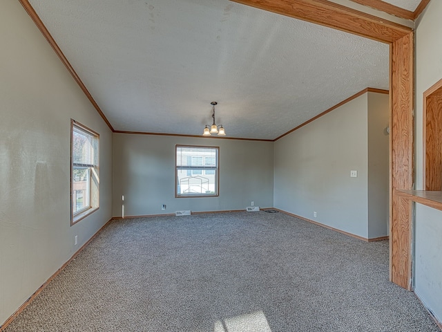 carpeted empty room featuring lofted ceiling, ornamental molding, a textured ceiling, and a notable chandelier