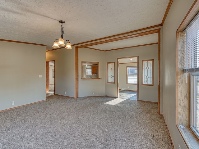 spare room featuring light carpet, a textured ceiling, a chandelier, and crown molding