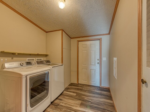 clothes washing area featuring a textured ceiling, separate washer and dryer, dark hardwood / wood-style floors, and ornamental molding