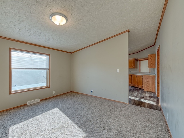 carpeted empty room featuring lofted ceiling, a textured ceiling, and ornamental molding