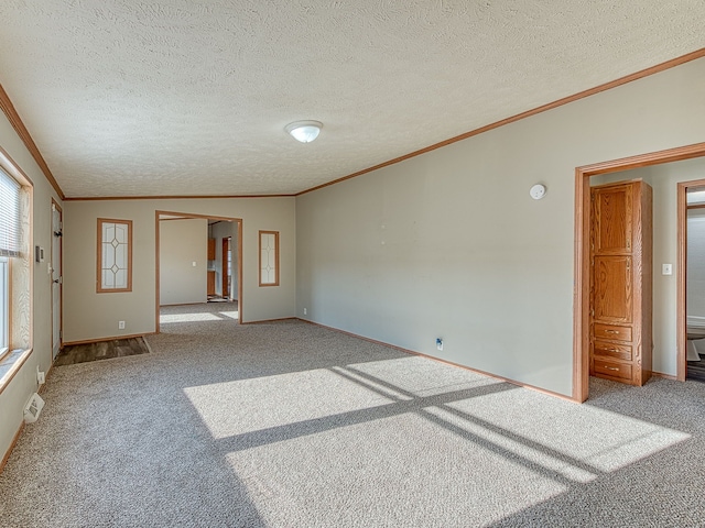 unfurnished room with a textured ceiling, carpet floors, and crown molding