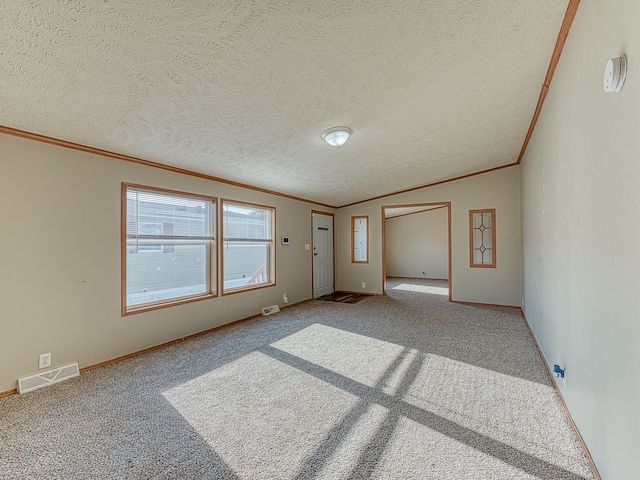 empty room featuring carpet flooring, a textured ceiling, and ornamental molding