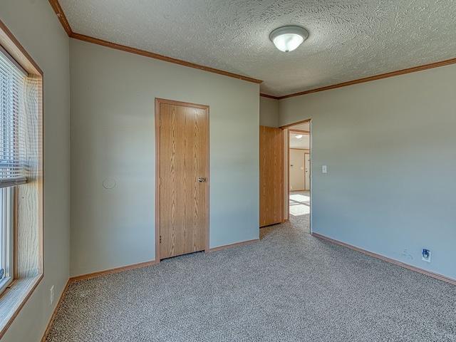 unfurnished bedroom with light carpet, a textured ceiling, and ornamental molding