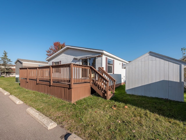 rear view of property with a deck and a yard