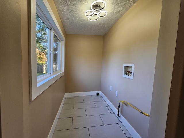 99 S Western Ave, Grant, MI 49327 - washroom featuring hookup for a washing machine, a textured ceiling, baseboards, and tile patterned floors