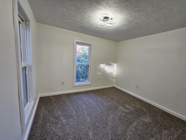99 S Western Ave, Grant, MI 49327 - unfurnished room featuring dark carpet, a textured ceiling, and baseboards