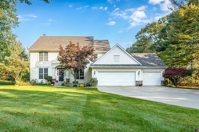 colonial-style house featuring a garage and a front yard