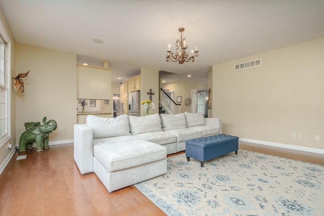 living room featuring light hardwood / wood-style floors and an inviting chandelier