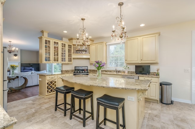 kitchen featuring stainless steel appliances, light stone counters, pendant lighting, a breakfast bar, and a kitchen island