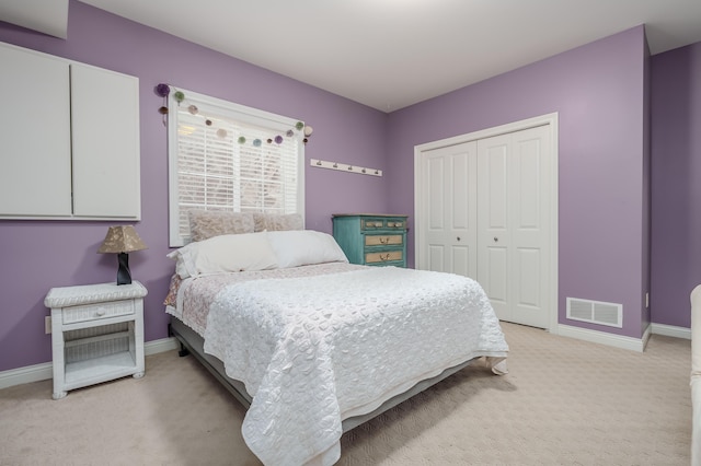 bedroom featuring light colored carpet and a closet