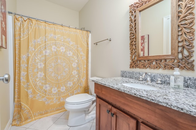 bathroom with toilet, vanity, and tile patterned floors