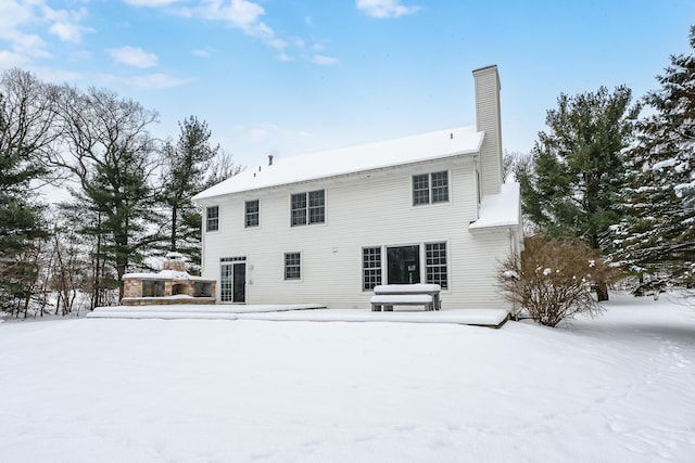 view of snow covered back of property