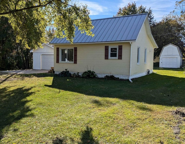 view of front of home featuring a garage, an outbuilding, and a front yard