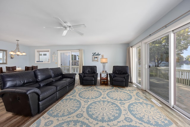 living room with wood-type flooring and ceiling fan with notable chandelier