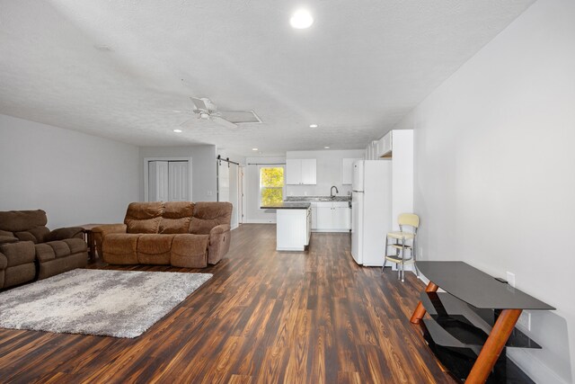 living room featuring ceiling fan, dark hardwood / wood-style floors, and a textured ceiling