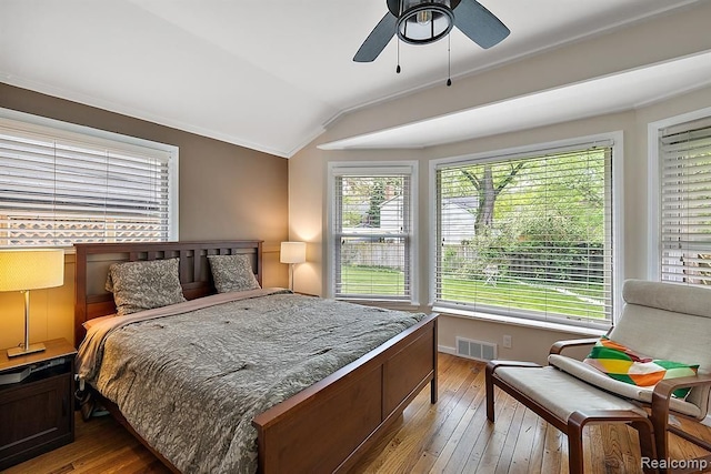 bedroom with ceiling fan, light wood-type flooring, crown molding, and vaulted ceiling