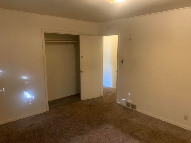 unfurnished bedroom with a closet and carpet floors