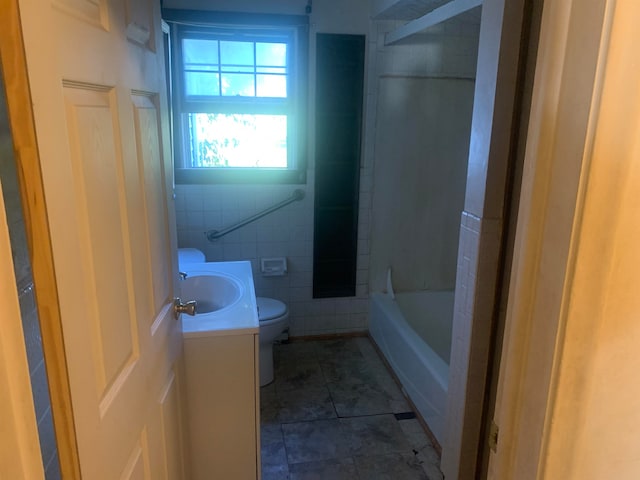 full bathroom with vanity, shower / washtub combination, tile walls, tile patterned flooring, and toilet