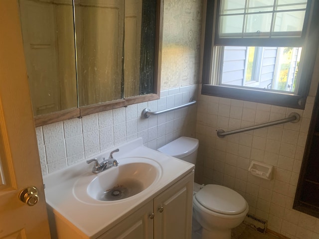 bathroom with vanity, toilet, and tile walls