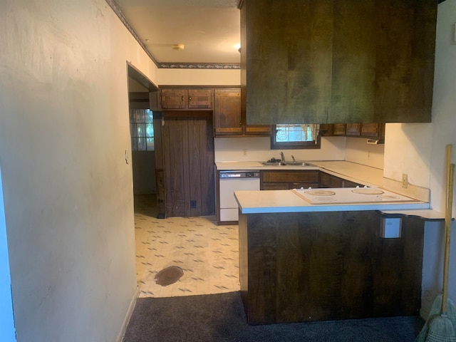 kitchen with kitchen peninsula, white appliances, and sink