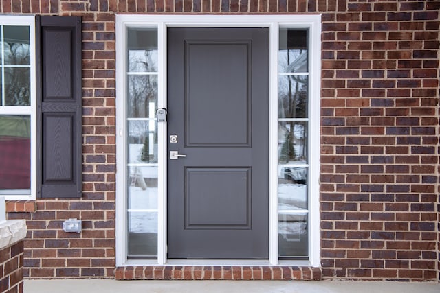 entrance to property featuring brick siding