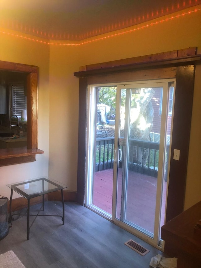 doorway to outside with hardwood / wood-style floors and sink